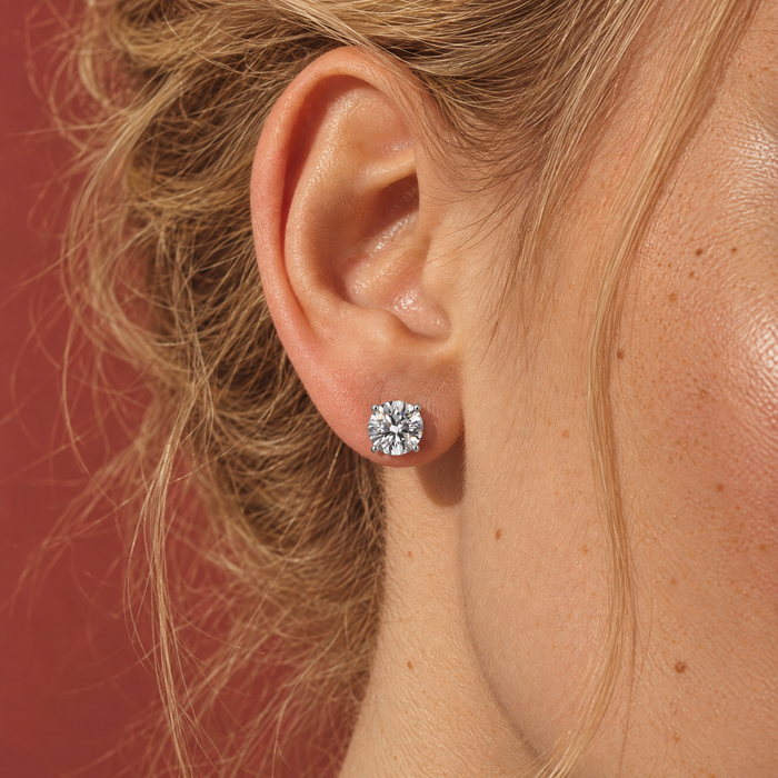 Close-up of one of a pair of 3 carat lab-grown diamond stud earrings in 14K white gold, worn on the ear, AI-generated image — DEEVE