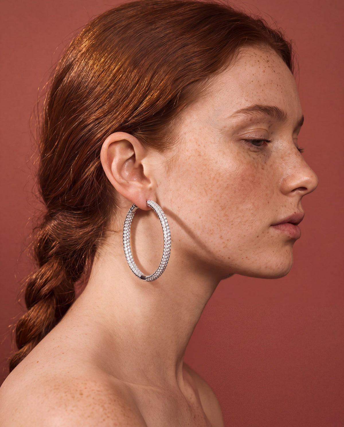 Woman in profile wearing a natural diamond pavé hoop earring in 14K white gold