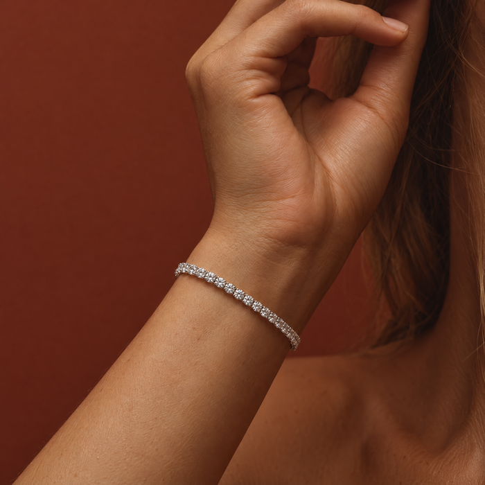 4 carat lab-grown diamond tennis bracelet in 14K white gold worn on the wrist, close-up, AI-generated image — DEEVE
