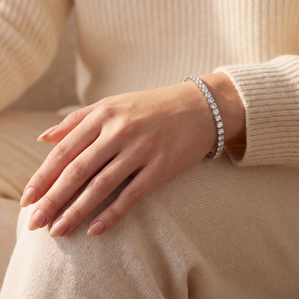 6 carat lab-grown diamond tennis bracelet in 14K white gold worn on the wrist, hand resting on the knee, AI-generated image — DEEVE