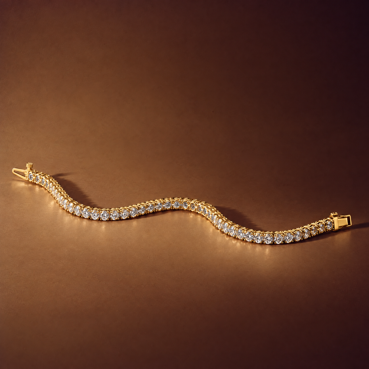 7 carat lab-grown diamond tennis bracelet in 14K yellow gold lying flat on a brown background, AI-generated image — DEEVE