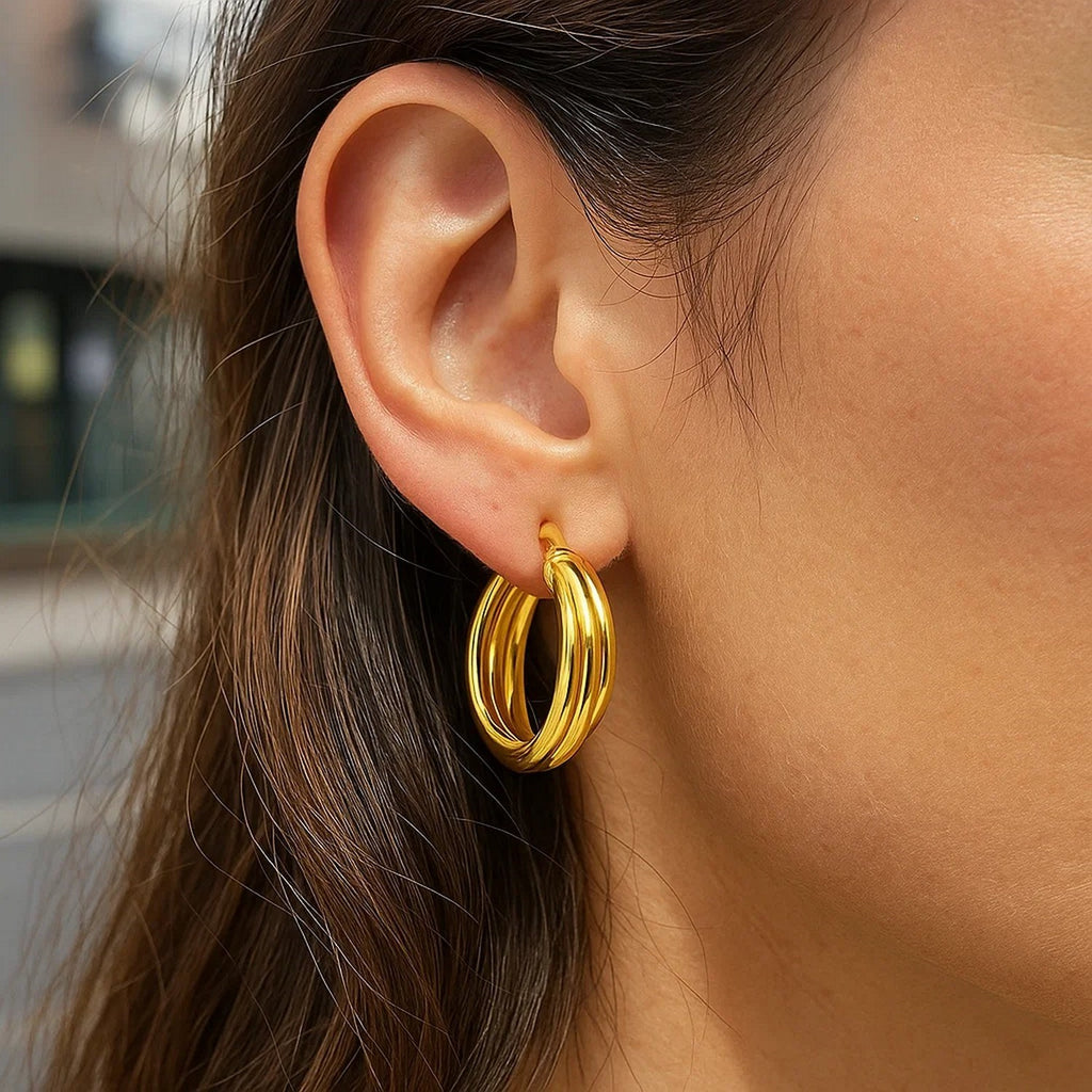 Close-up of an interlocking trinity 14K yellow gold hoop on the ear