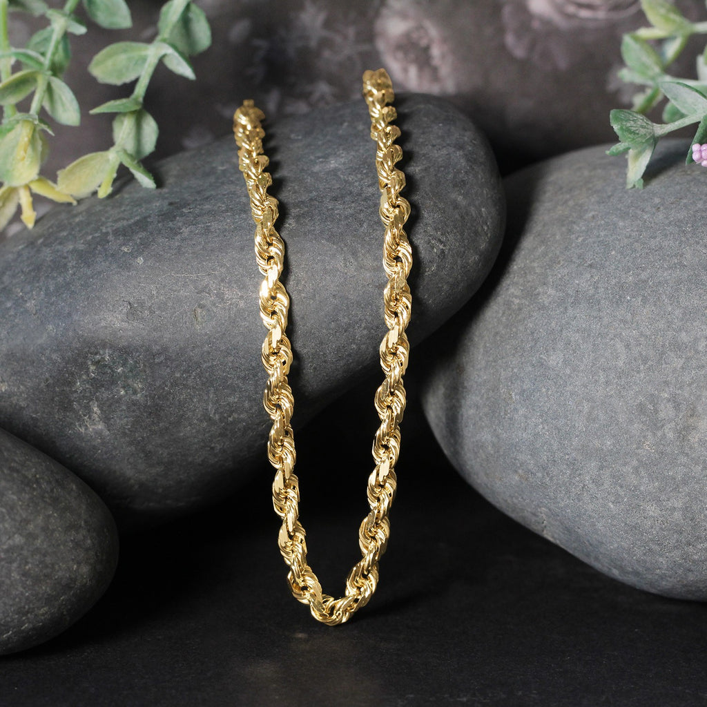 Rope chain in 14K yellow gold draped over two stones