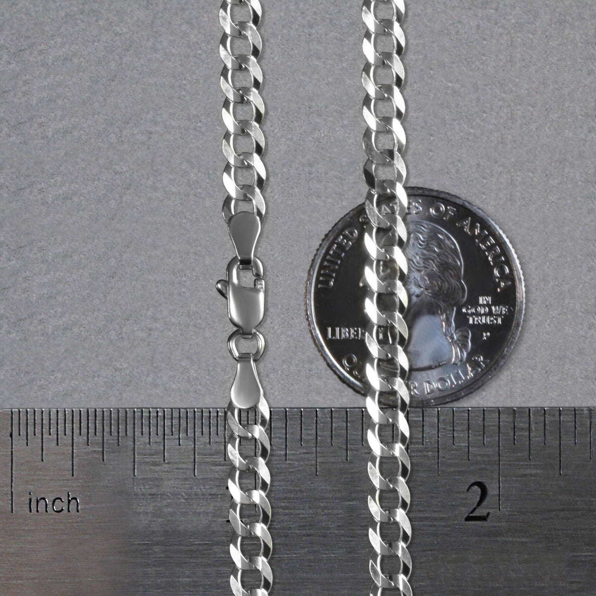 4.70mm curb chain in 14K white gold beside an inch ruler and a coin for scale
