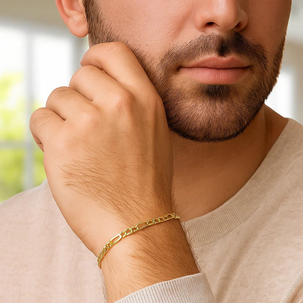 Figaro bracelet in 14K yellow gold worn by a man in a beige sweater