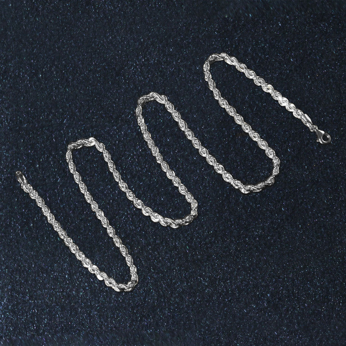 Diamond-cut rope chain in 14K white gold laid out in loops