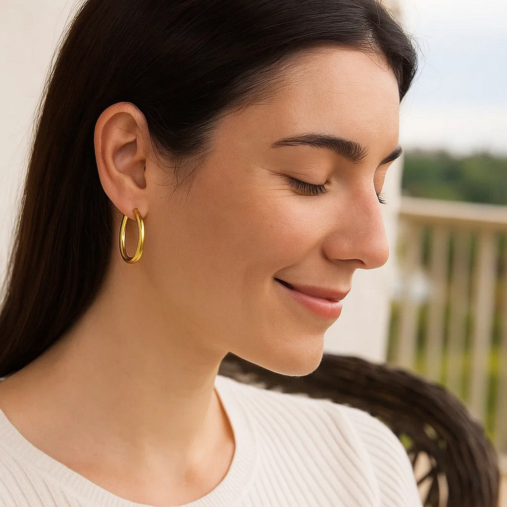 30mm 4mm-wide 14K yellow gold hoop worn with a white top