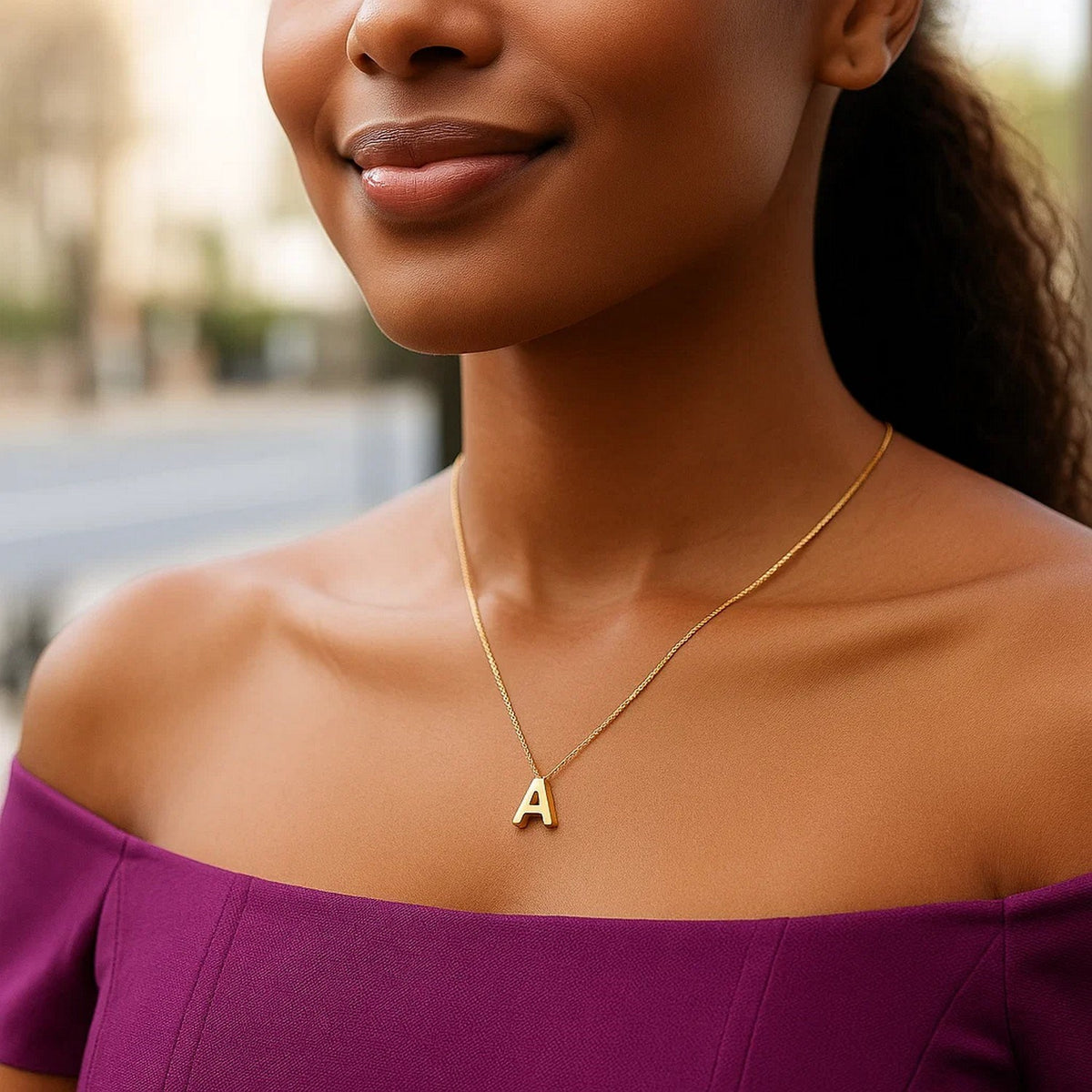 Block letter A initial necklace in 14K yellow gold worn at the neckline