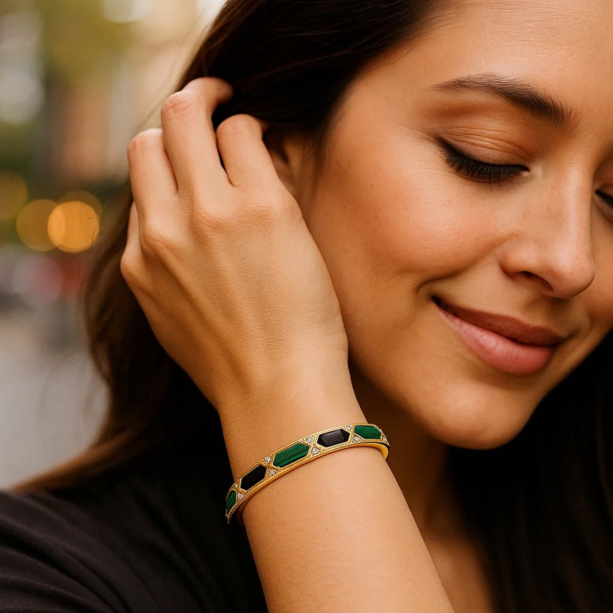 Woman wearing the 14K yellow gold onyx and malachite bangle