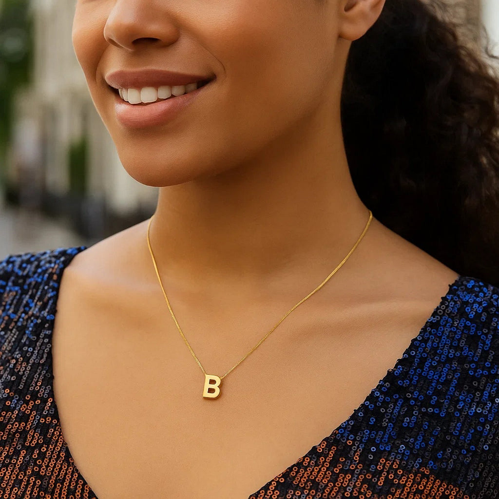 Block letter B initial necklace in 14K yellow gold worn at the neckline