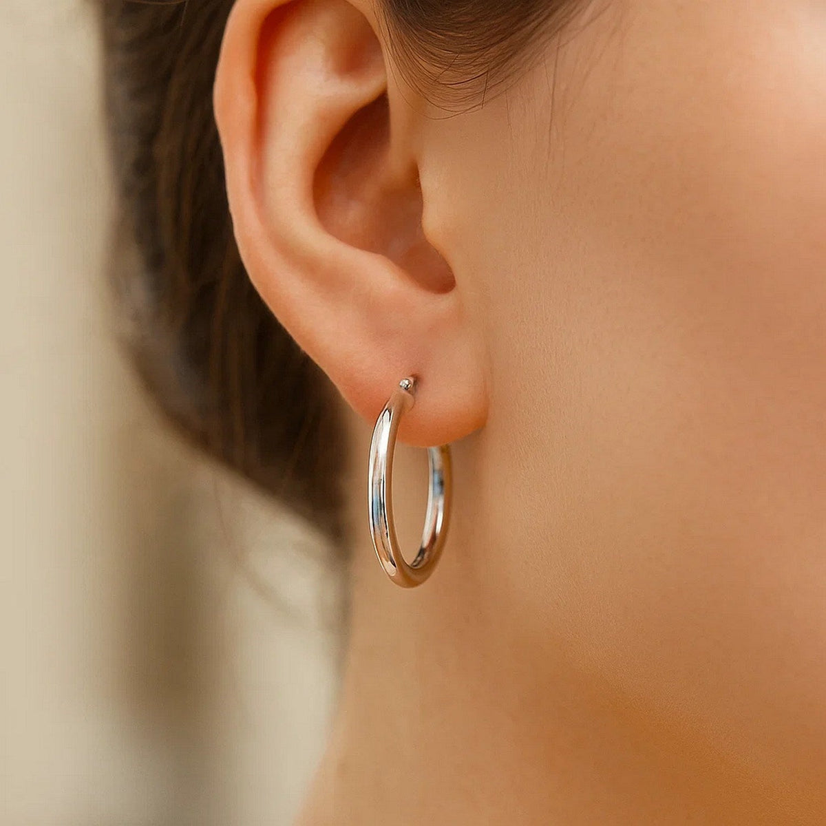 Close-up of a 20mm 14K white gold hoop on the ear