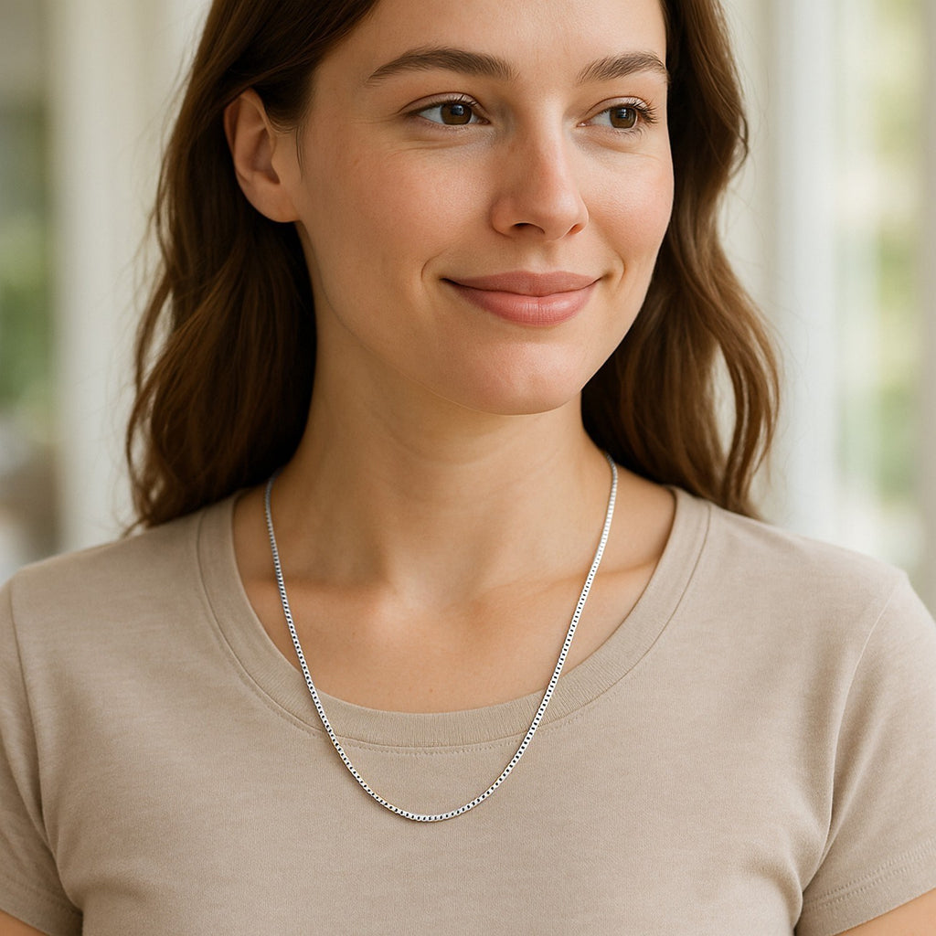 1.4mm box chain in 14K white gold worn at the collarbone with a beige top