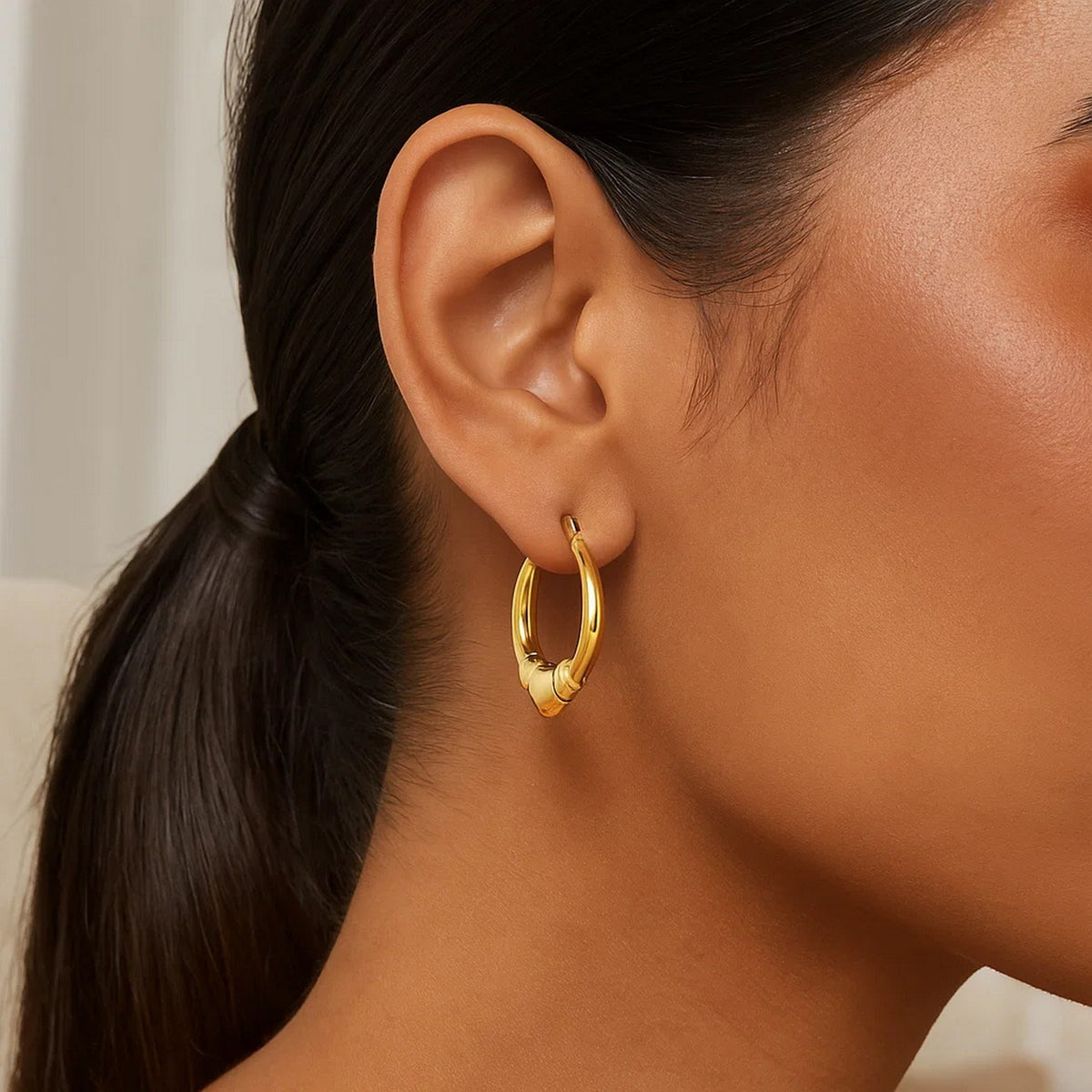 Heart-shaped 14K yellow gold hoop worn