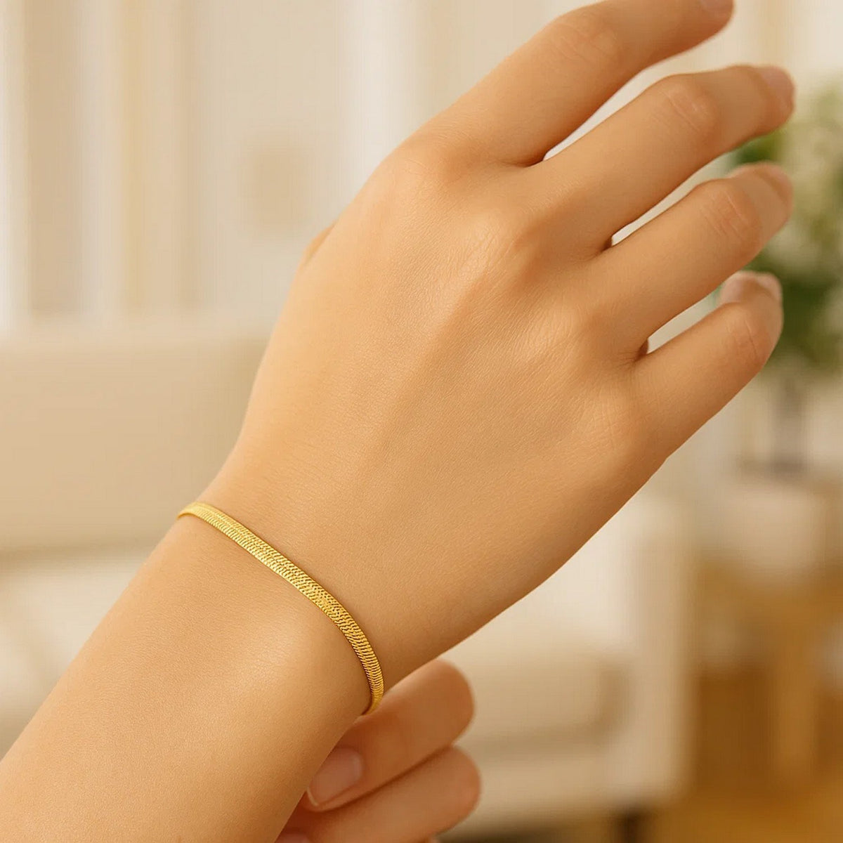 Herringbone bracelet in 14K yellow gold worn on the wrist