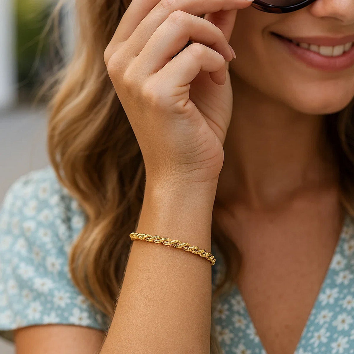 Woman in a floral dress wearing a yellow gold rope bracelet