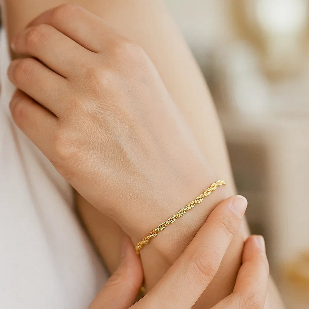 Rope bracelet in 14K yellow gold worn, hand resting on the forearm