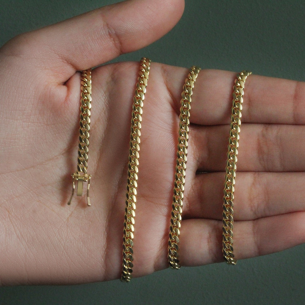 4.0mm solid Miami Cuban chain in 14K yellow gold held across an open palm