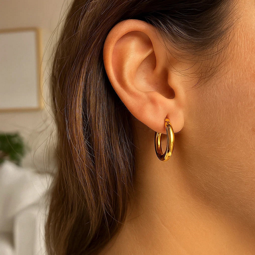 Close-up of a 15mm 3mm-wide 14K yellow gold hoop on the ear