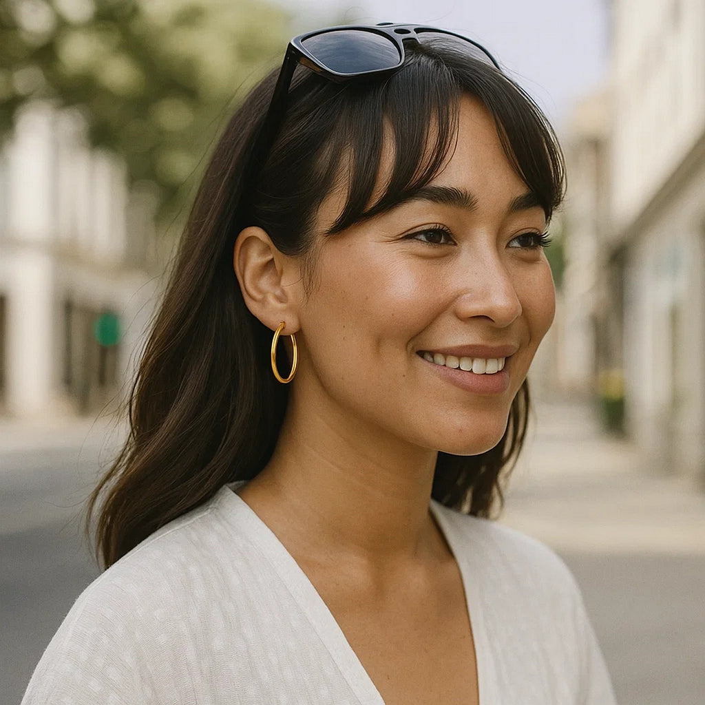 20mm 14K yellow gold hoop worn with sunglasses pushed up, outdoors