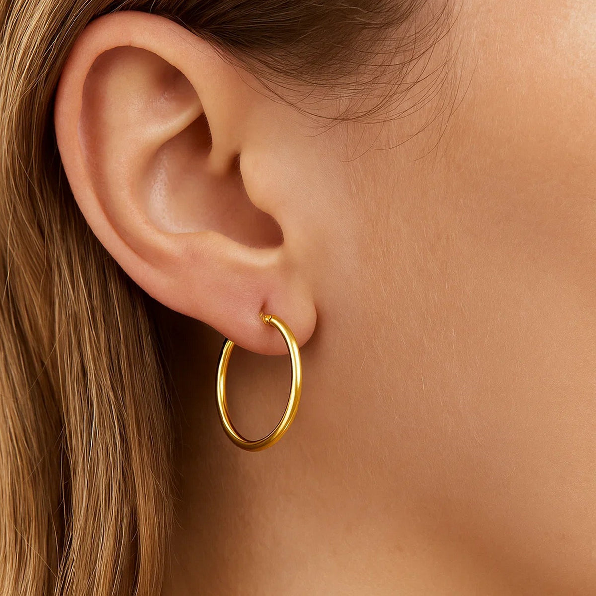 Close-up of a 20mm 14K yellow gold hoop on the ear