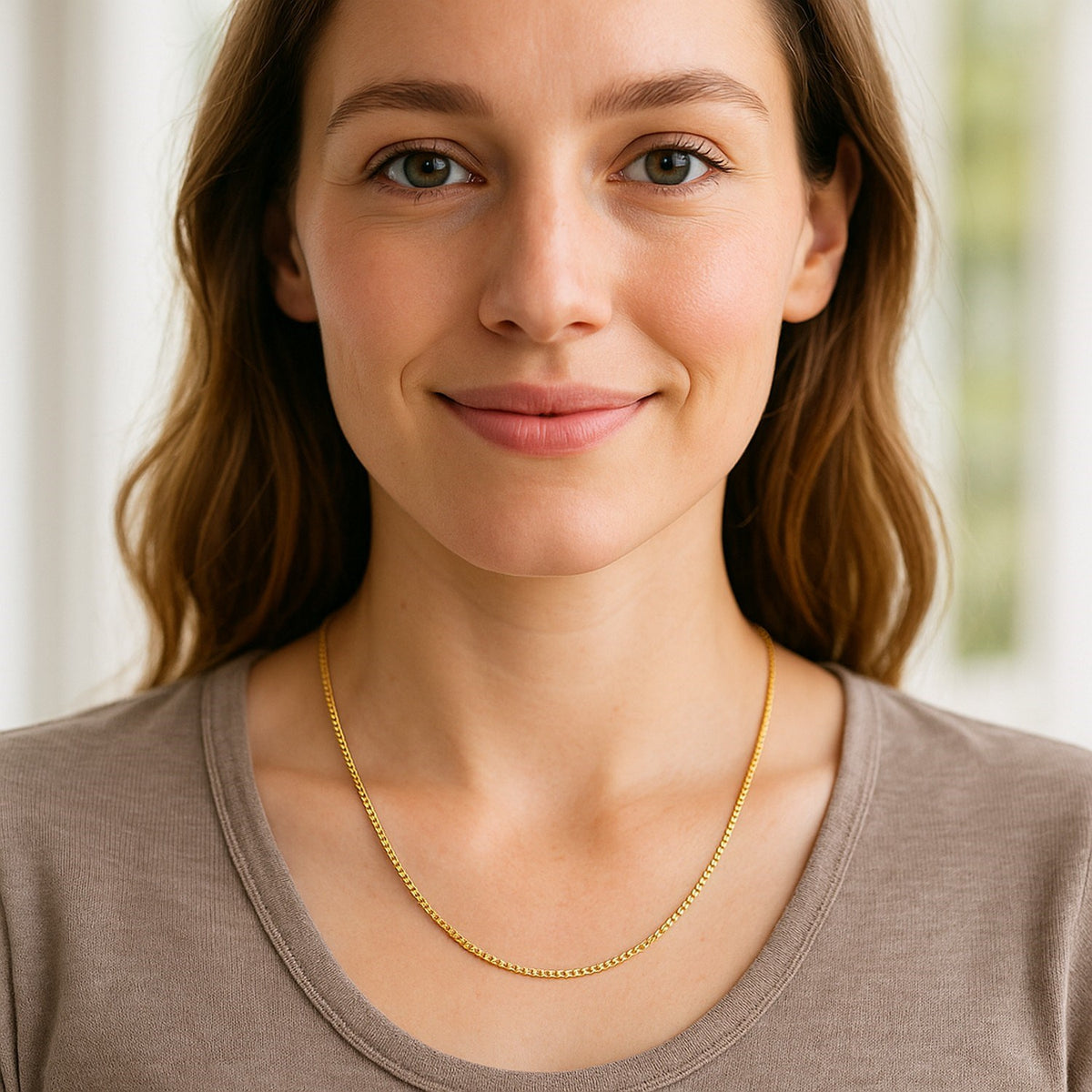 1.4mm box chain in 14K yellow gold worn at the collarbone with a beige top