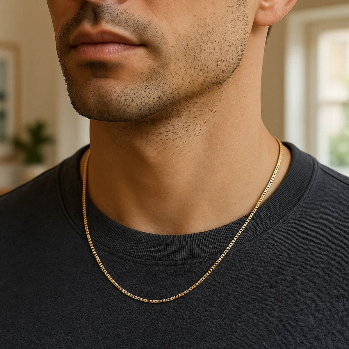 Box chain in 14K yellow gold worn over a black T-shirt