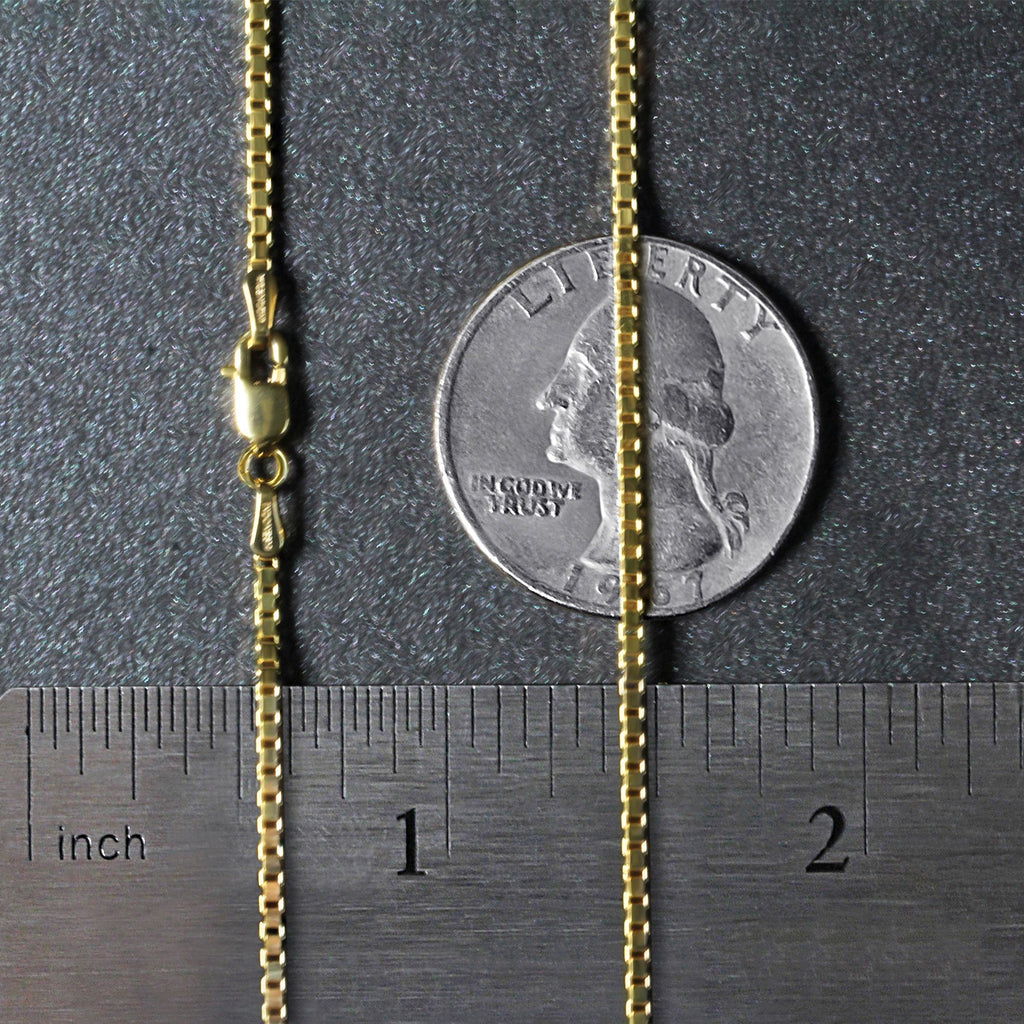 1.4mm box chain in 14K yellow gold beside an inch ruler and a coin for scale