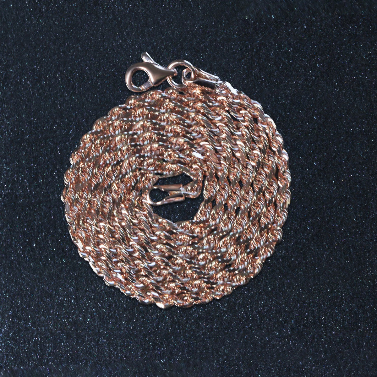 14K rose gold rope chain, 4.00mm, coiled on a dark surface