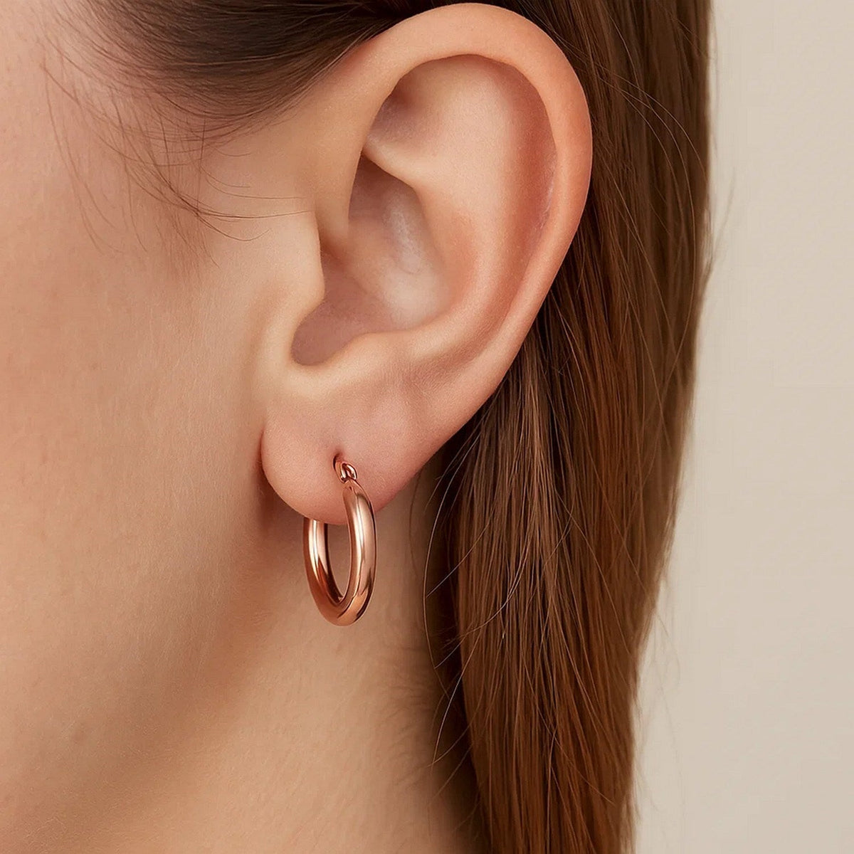 Close-up of a 15mm 14K rose gold hoop on the ear