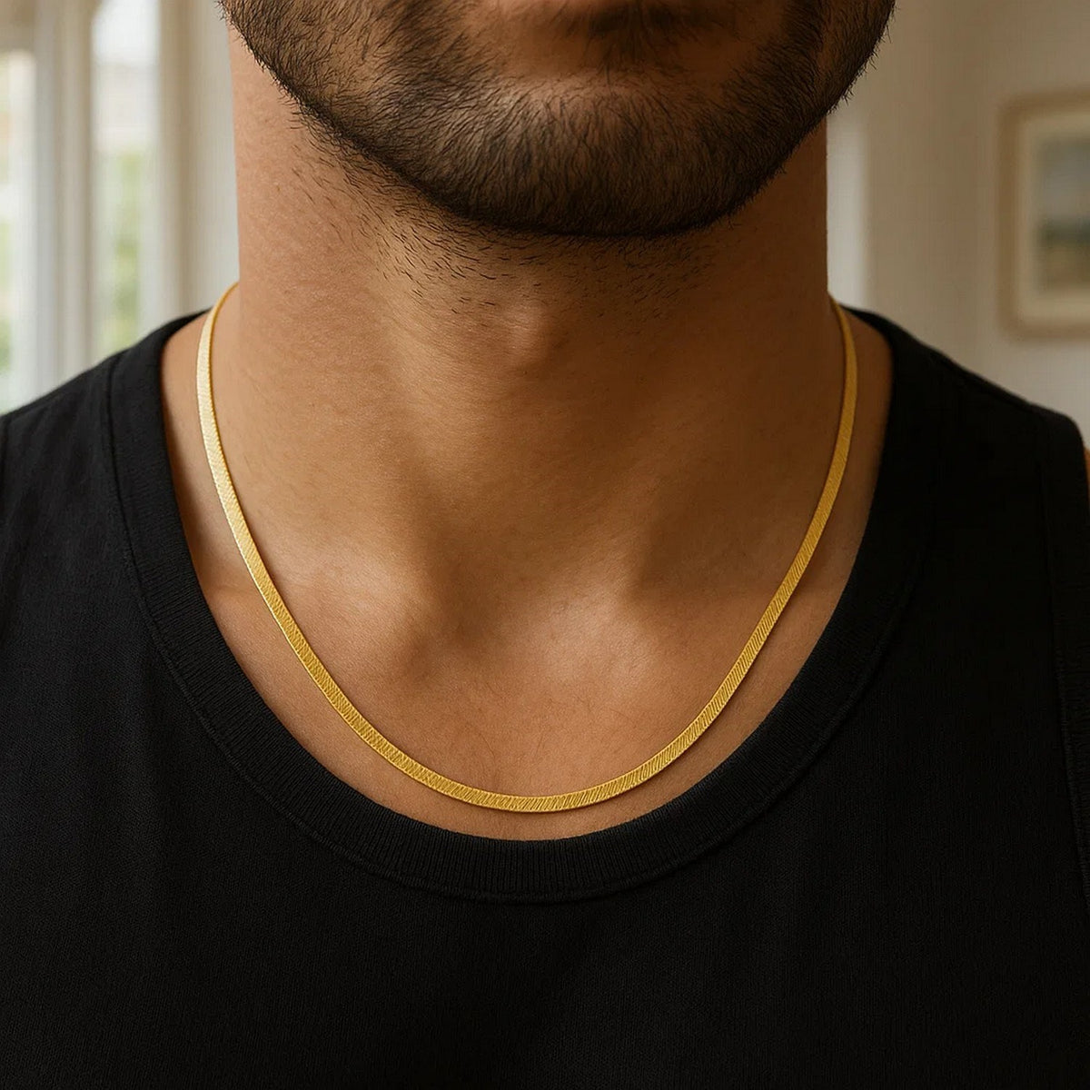 3.80mm herringbone chain in 14K yellow gold worn over a black T-shirt