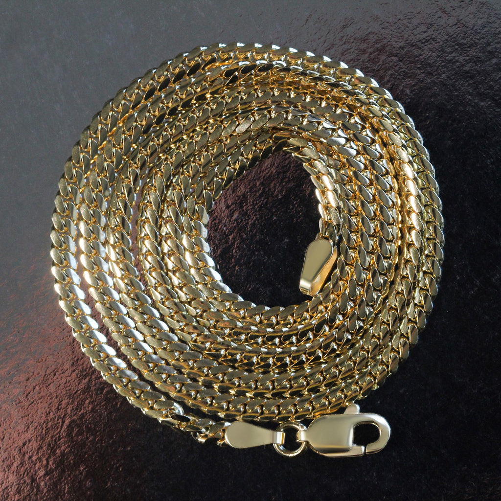14K yellow gold solid Miami Cuban chain, 2.60mm, coiled on a dark surface