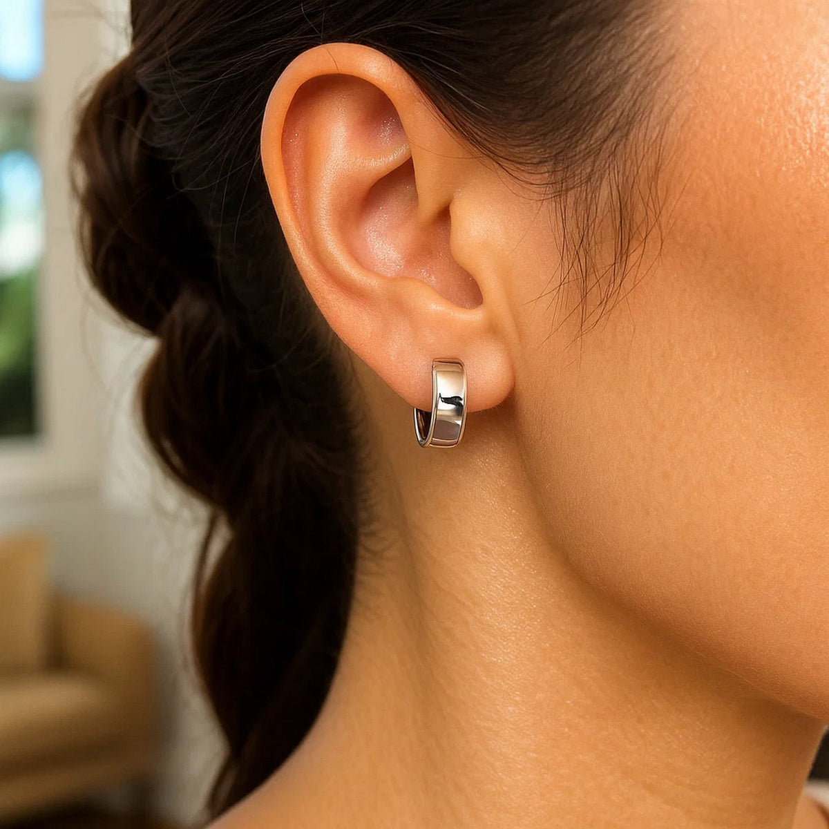 Close-up of a snuggable 14K white gold huggie worn