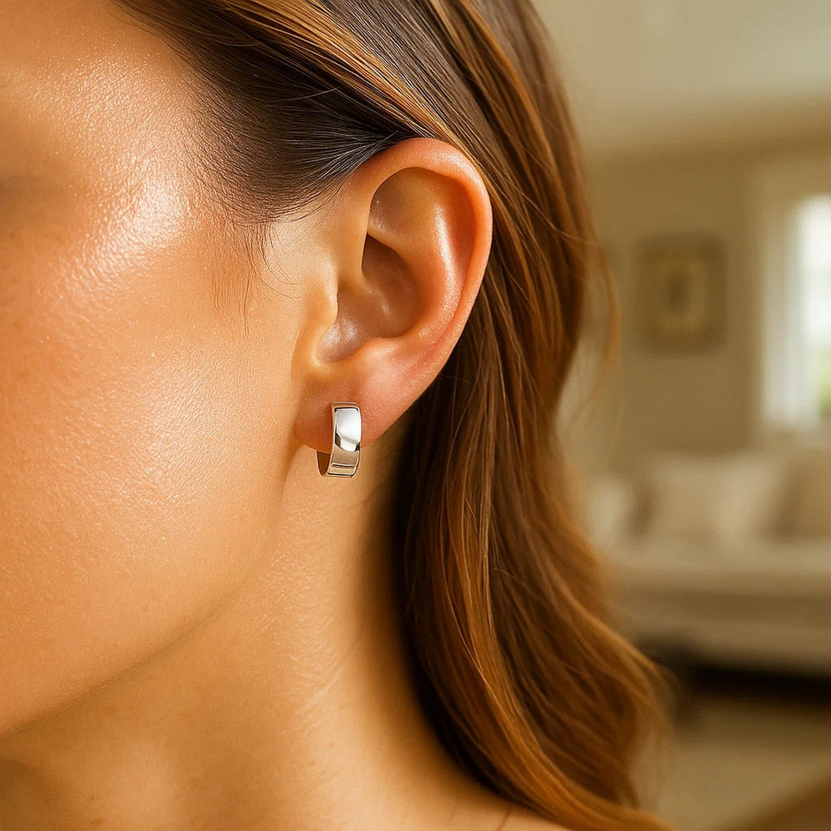 Snuggable 14K white gold huggie on the ear, side view