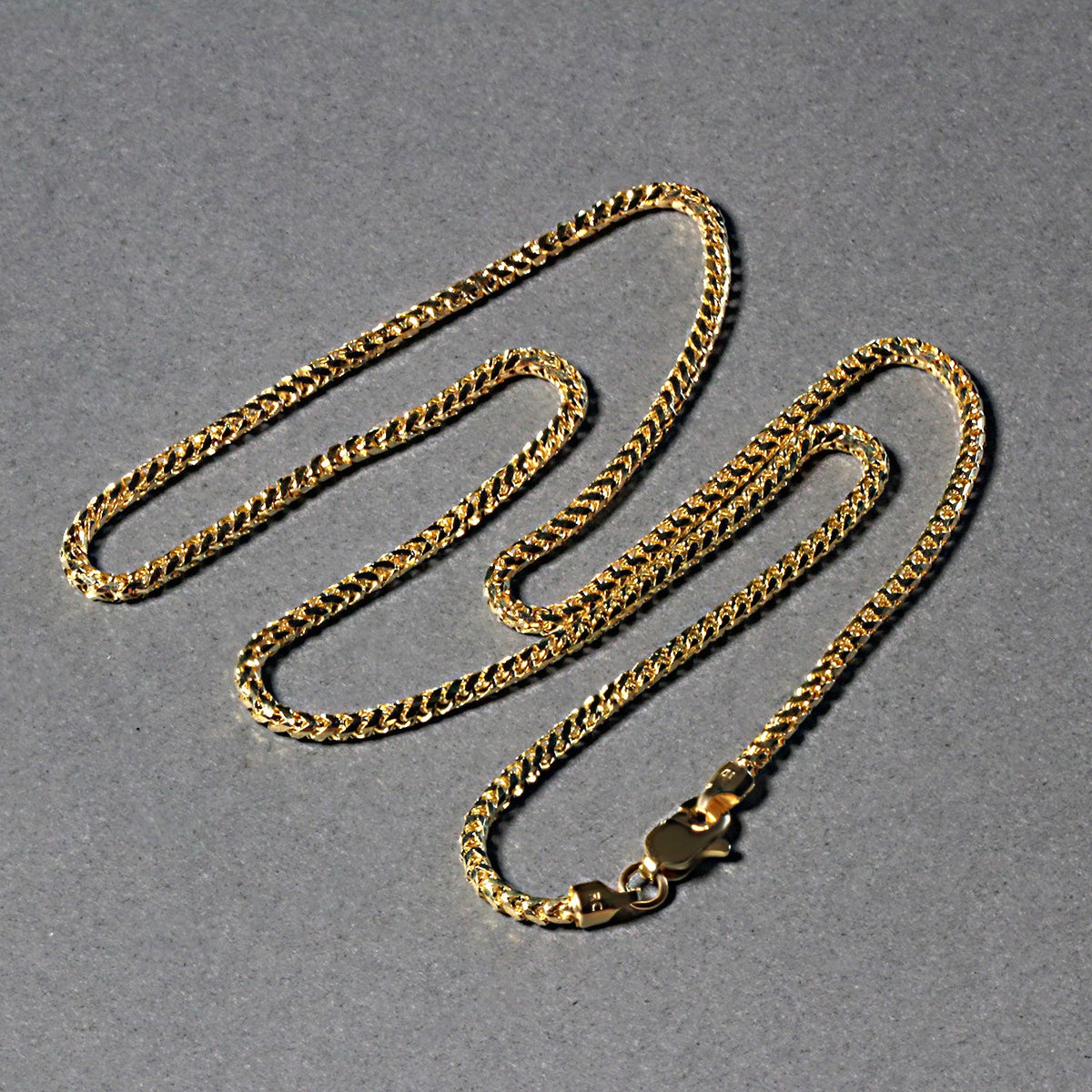 Diamond-cut Franco chain in 14K yellow gold laid out in loops