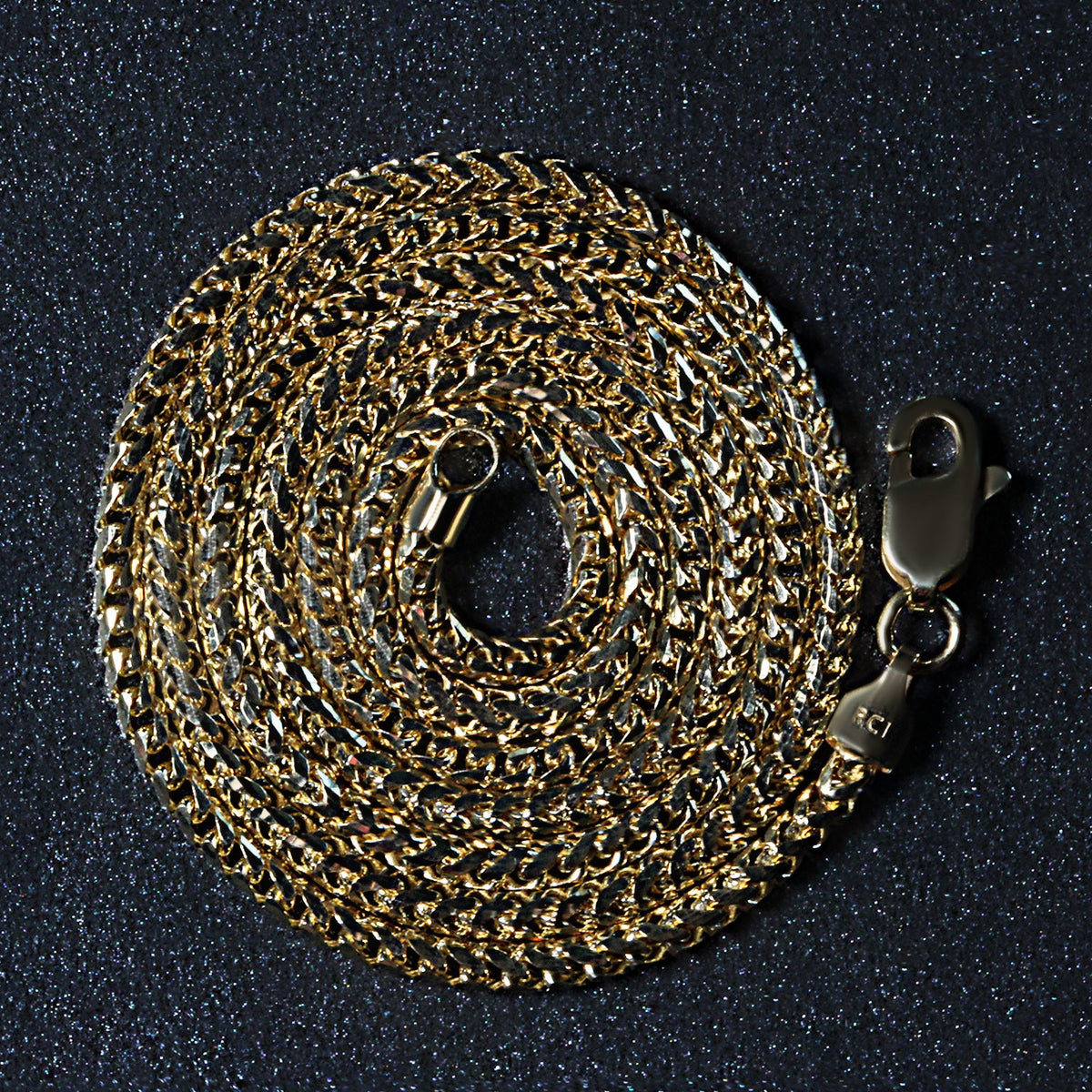 14K yellow gold Franco chain, 2.20mm, coiled on a dark surface