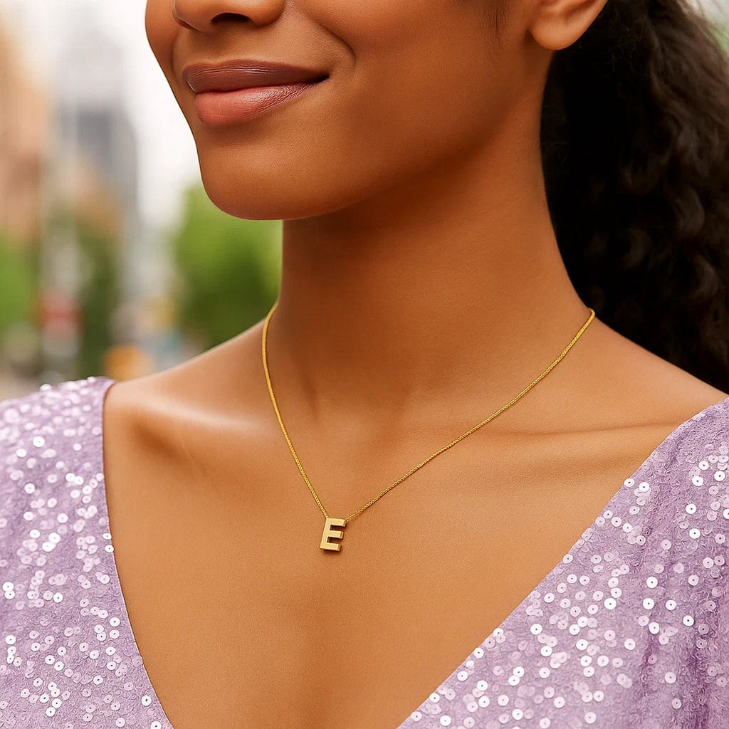 Block letter E initial necklace in 14K yellow gold worn, second view