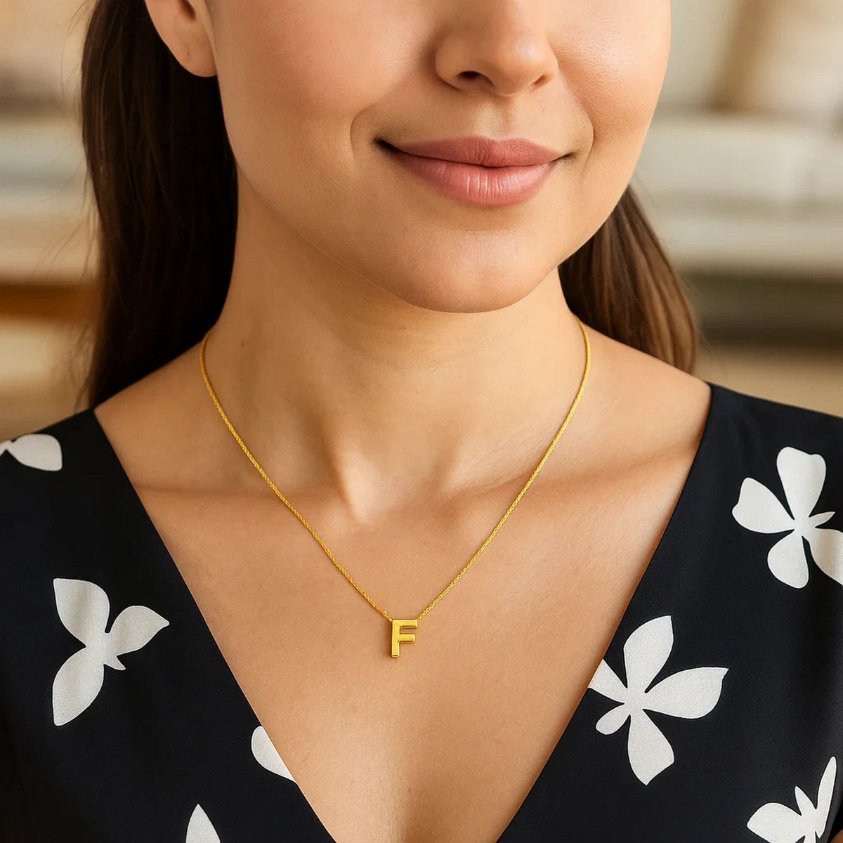 Block letter F initial necklace in 14K yellow gold worn at the neckline