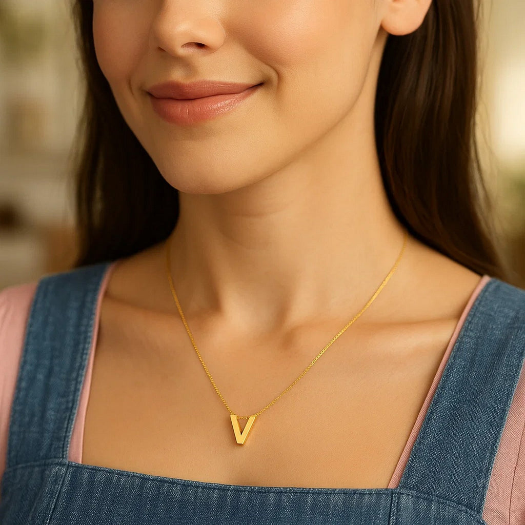 Block letter V initial necklace in 14K yellow gold worn at the neckline