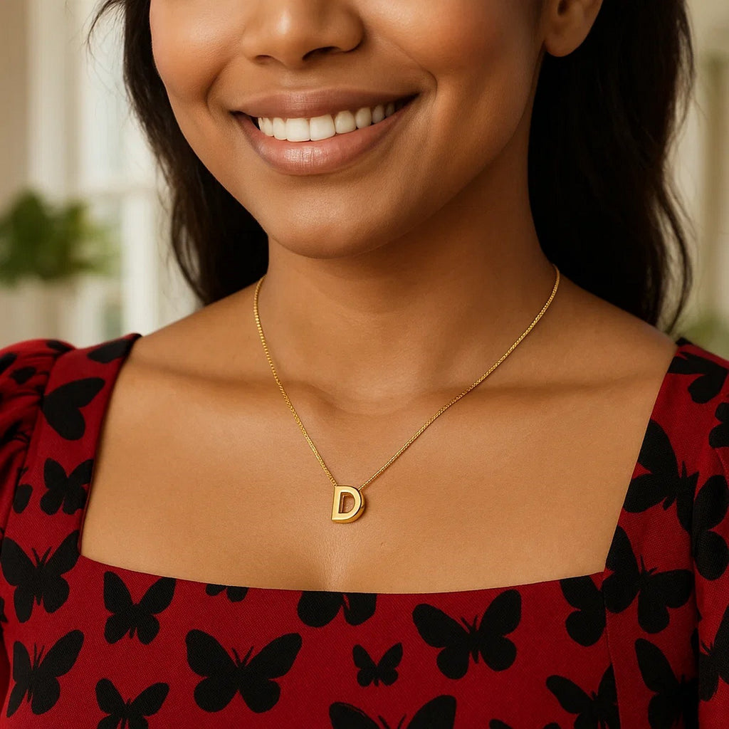 Block letter D initial necklace in 14K yellow gold worn at the neckline