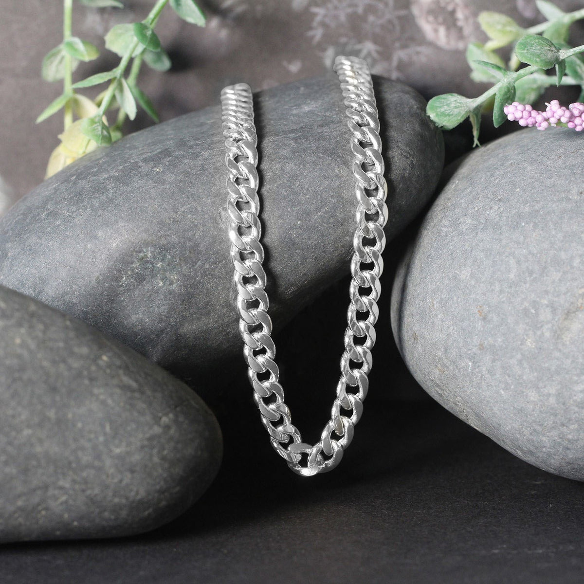 Miami Cuban chain in 14K white gold draped over two stones
