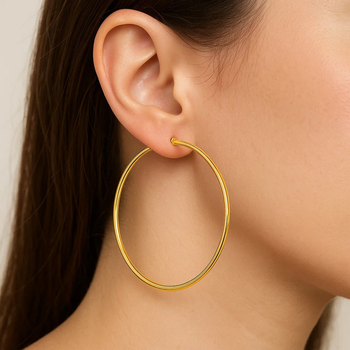Close-up of a 60mm 14K yellow gold hoop on the ear, showing its size