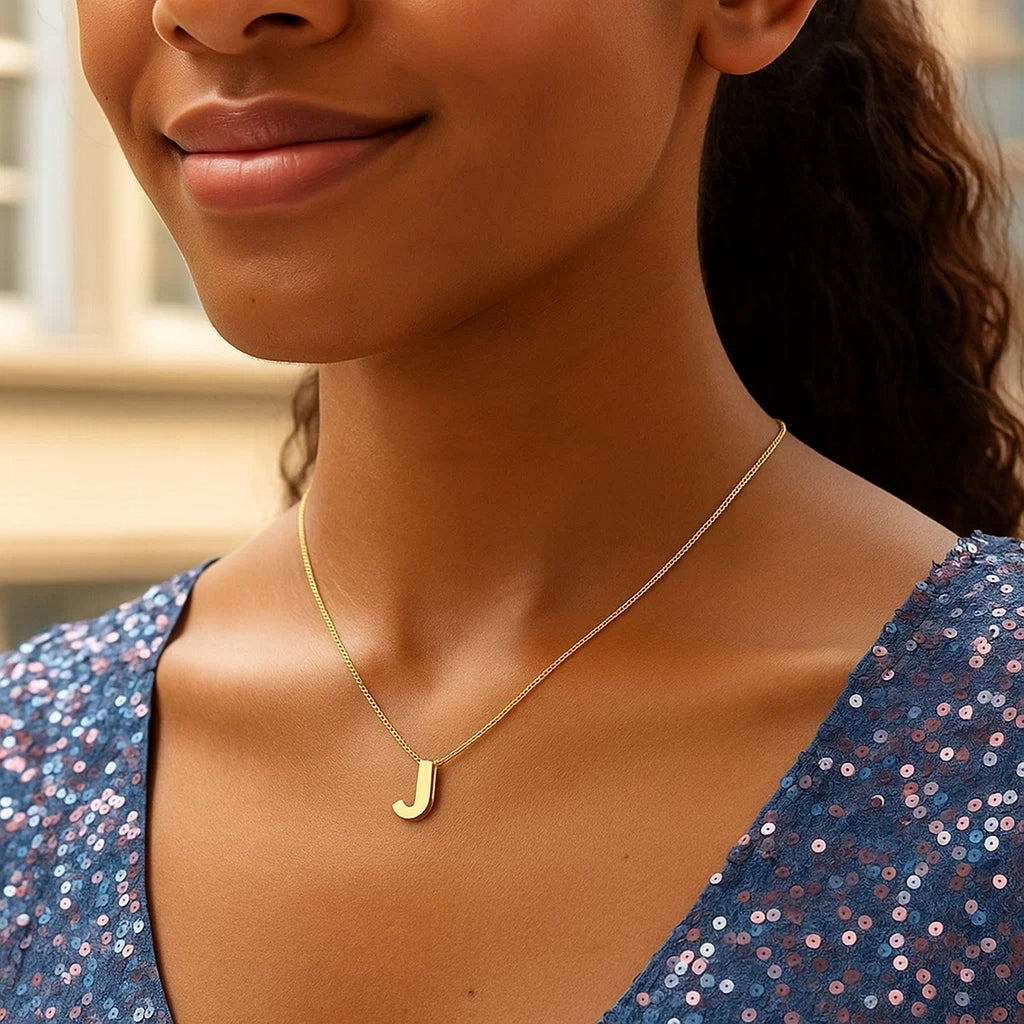 Block letter J initial necklace in 14K yellow gold worn at the neckline
