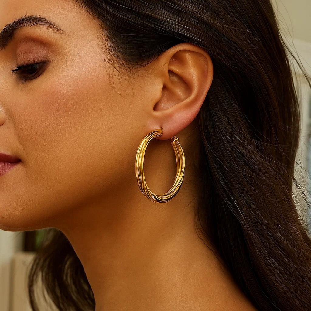 Close-up of a large twisted 14K yellow gold hoop on the ear
