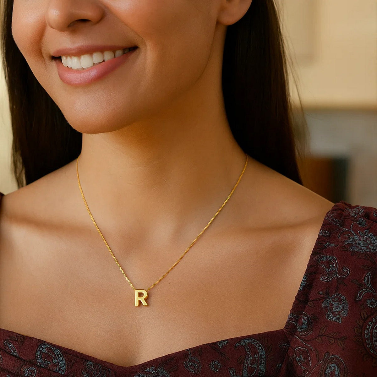 Block letter R initial necklace in 14K yellow gold worn at the neckline