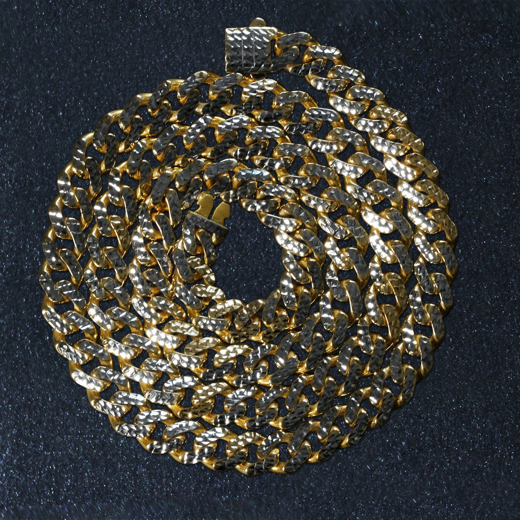 14K two-tone gold Miami Cuban chain, 8.00mm, coiled on a dark surface