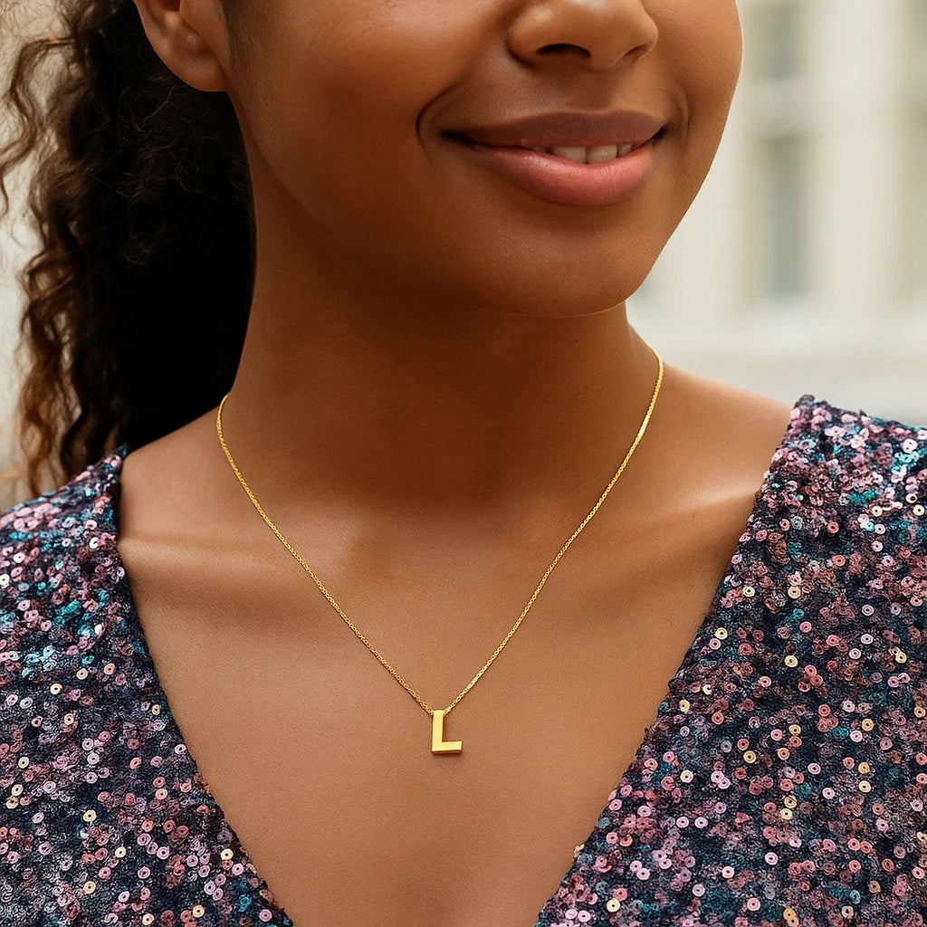Block letter L initial necklace in 14K yellow gold worn at the neckline
