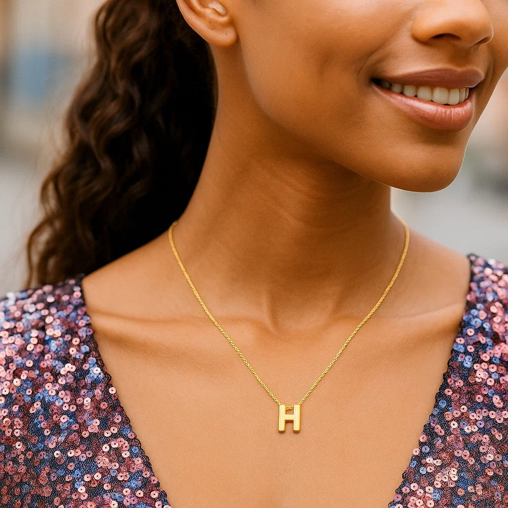 Block letter H initial necklace in 14K yellow gold worn at the neckline