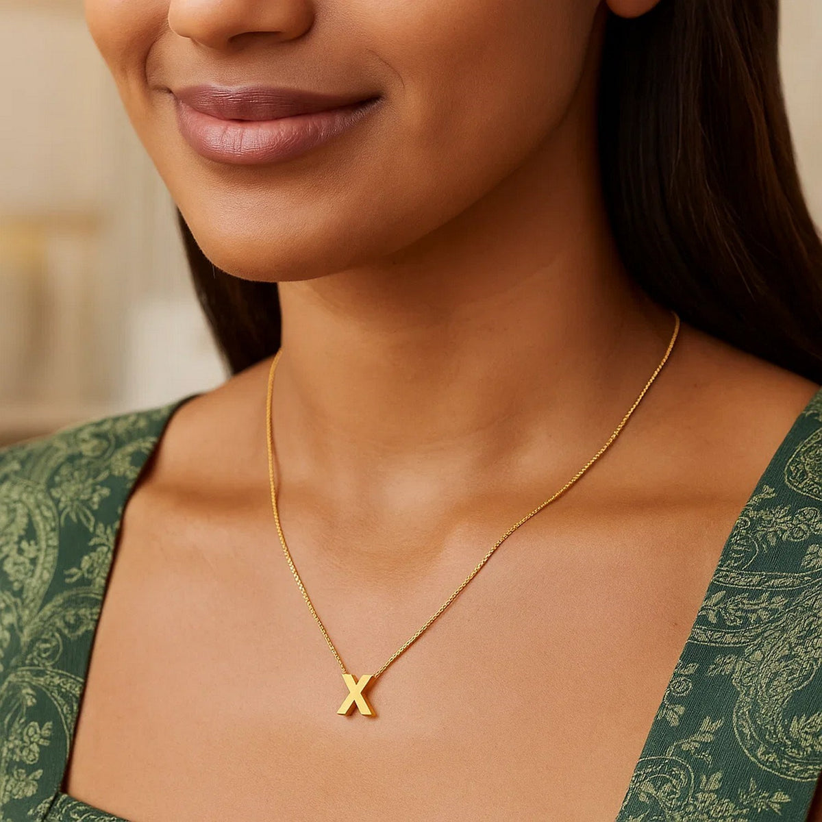 Block letter X initial necklace in 14K yellow gold worn at the neckline