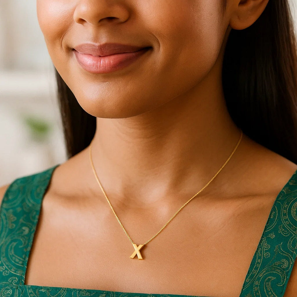 Block letter X initial necklace in 14K yellow gold worn, second view