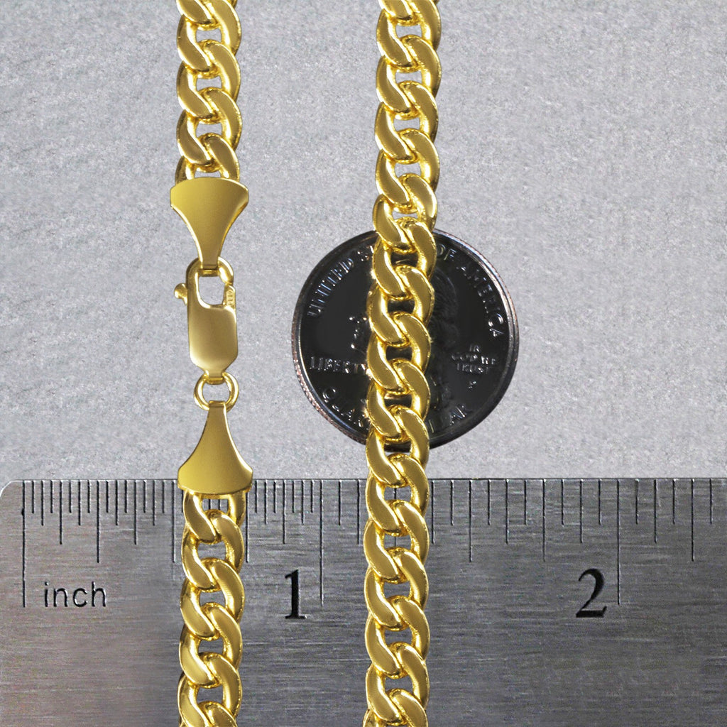 7.00mm Miami Cuban chain in 14K yellow gold beside an inch ruler and a coin for scale